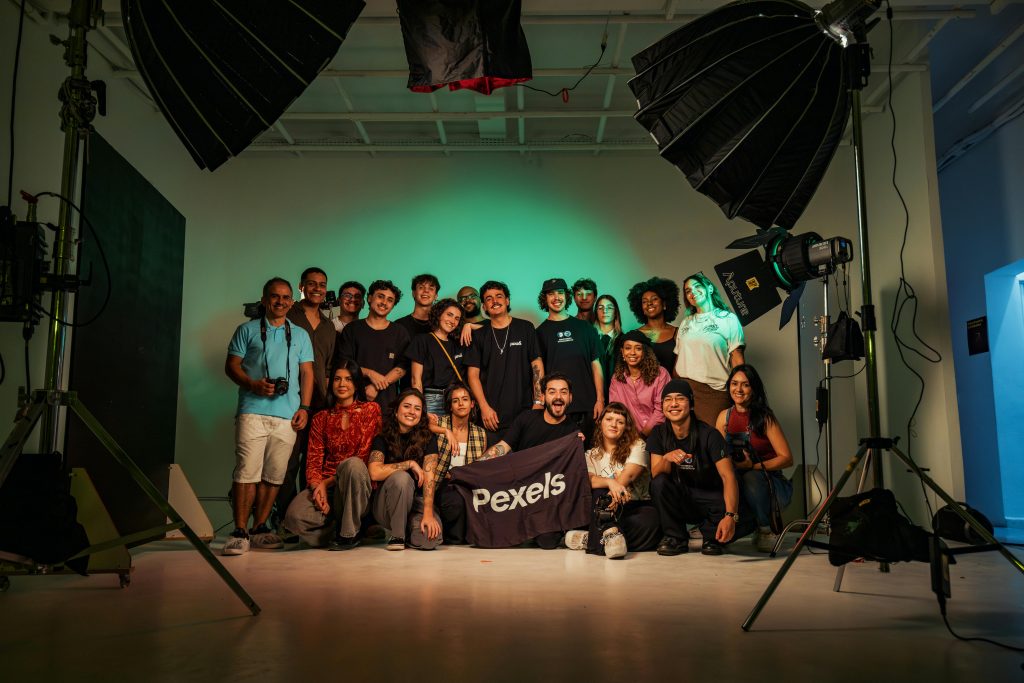 A group of young professionals posing together in a well-lit photography studio.